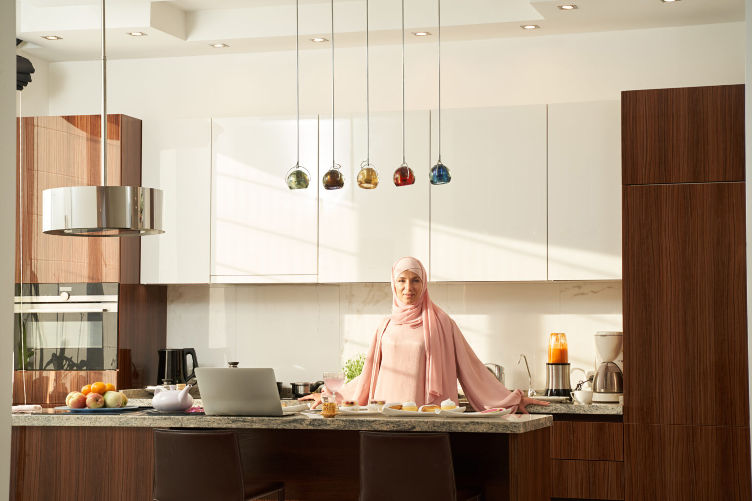 Arab Islamic woman standing in kitchen with modern interior